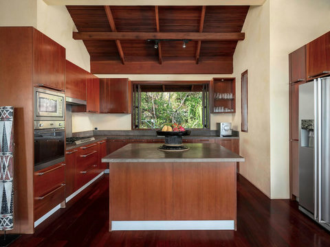Fully-equipped modern kitchen with elegant red cabinetry and garden window view - Villa Soluna 5-bedroom luxury hillside retreat southern Koh Samui