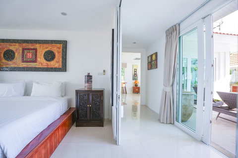 Traditional Thai-style villa entrance with ornate wooden doors and lush tropical garden