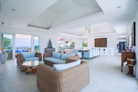 Bright open-plan living area with curved white sofas and blue cushions
