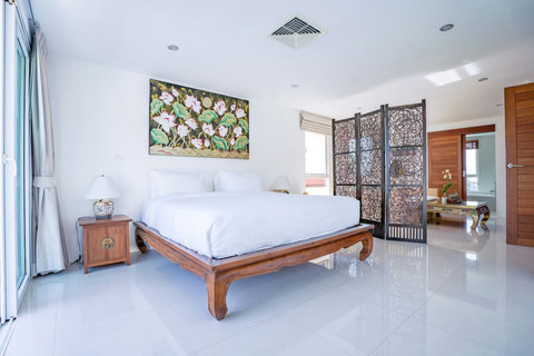 Elegant master bedroom with queen bed and ornate wooden headboard