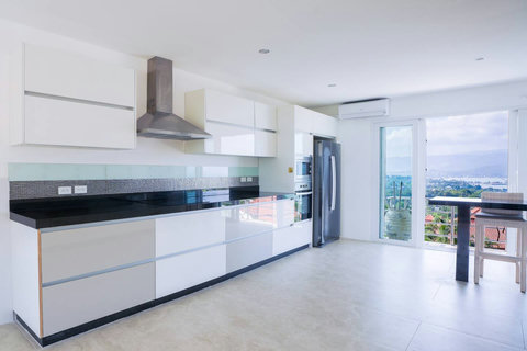 Bright open-plan living space with balcony access and garden views