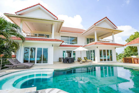 Multi-story villa with traditional Thai-style roof and terraces