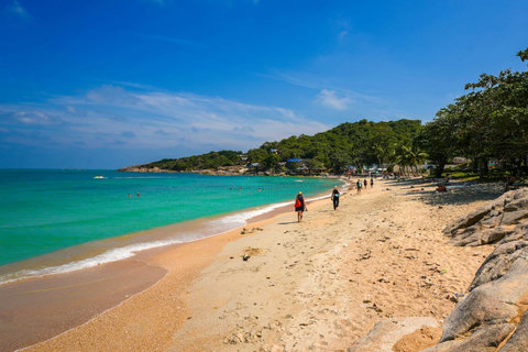 Tropical beach with crystal-clear waters and green hillside