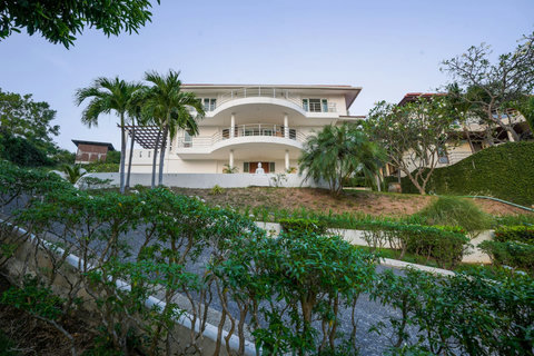 Villa exterior with balconies and lush green garden