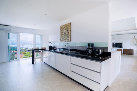 Spacious modern kitchen with white cabinetry and breakfast counter