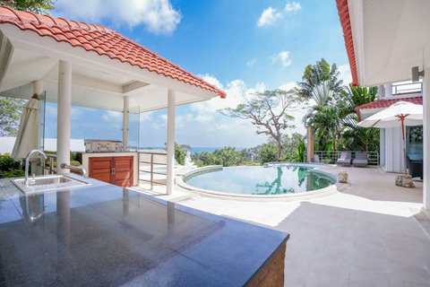 Villa poolside terrace with red tile roof and tropical views