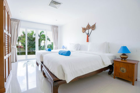 Twin bedroom with matching beds and tropical plants