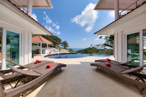 Pool deck with sun loungers and tropical garden views