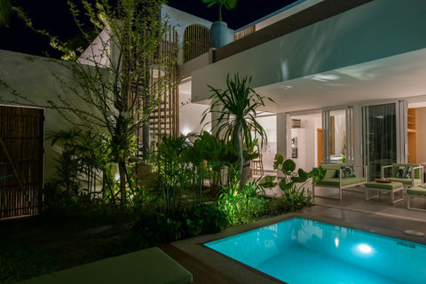 Stunning night view of C Villa with illuminated pool and modern architecture in Koh Samui, Thailand