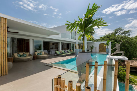 Crystal-clear pool framed by palm trees and modern villa design at C Villa, luxury Koh Samui estate