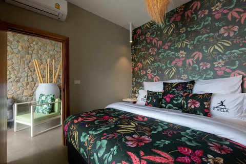 Exotic tropical bedroom with bold floral wallpaper and vibrant bedding at C Villa, Koh Samui Thailand