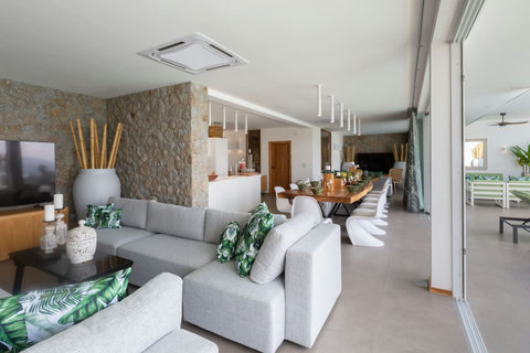 Air-conditioned open-plan living area with tropical greenery and modern furnishings at C Villa, Koh Samui