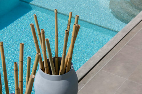 Decorative bamboo accents beside the turquoise private pool at C Villa, Koh Samui tropical estate