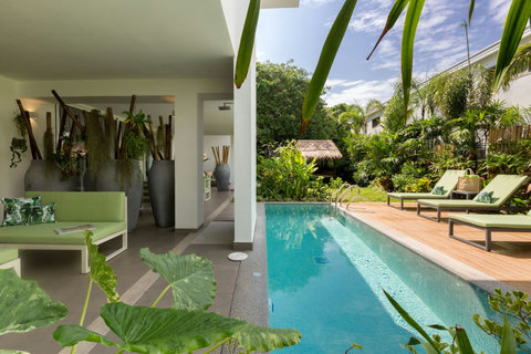 Poolside view of C Villa architecture surrounded by lush tropical gardens in Koh Samui, Thailand
