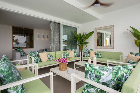 Open-air living room flowing into tropical garden with fresh flowers at C Villa, Koh Samui retreat