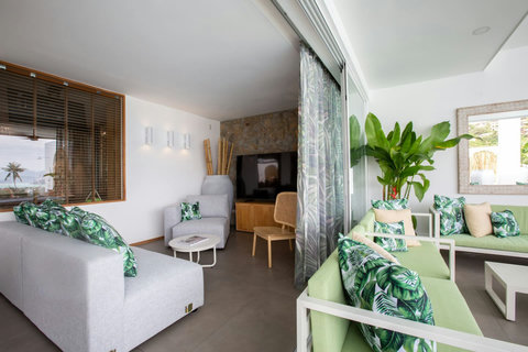 Tropical-themed living room with palm leaf cushions and indoor-outdoor flow at C Villa, Koh Samui