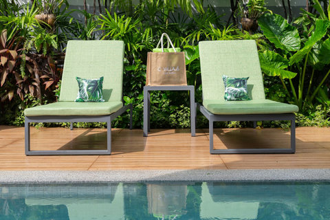 Teak wood pool deck with cushioned loungers overlooking the turquoise pool at C Villa, Koh Samui