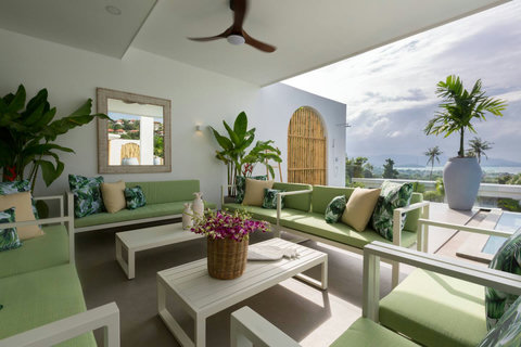 Elegant outdoor terrace lounge lit up at night with tropical flowers at C Villa, Koh Samui rental property