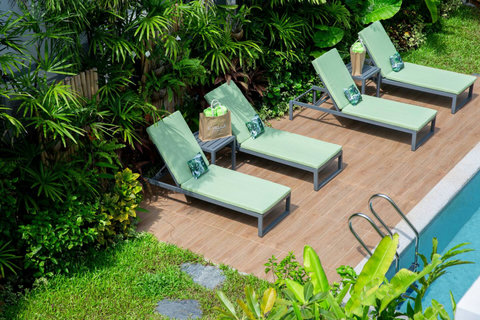 Expansive wooden sun deck with multiple loungers beside the pool at C Villa, Koh Samui holiday home