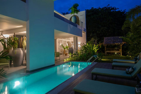 Magical evening ambiance with lit pool and mountain backdrop at C Villa, luxury Koh Samui vacation home