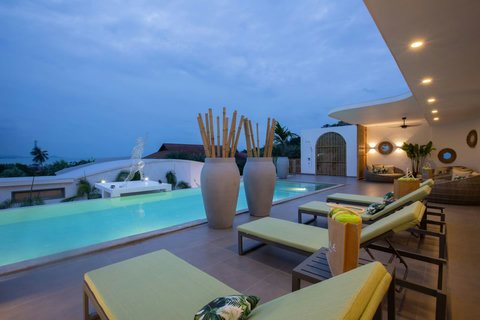 Modern outdoor dining pavilion beautifully lit at night beside the pool at C Villa, Koh Samui