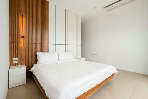 Master bedroom with decorative wood feature wall Mark Marlow Samui