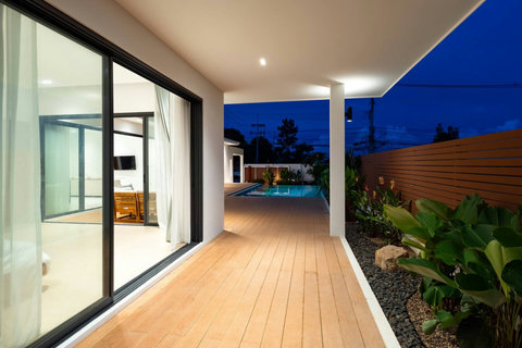 Villa side walkway with glass walls and tropical plants Koh Samui