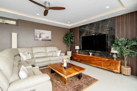 “Relax in the large sectional sofa with a 75” TV and natural wood accents