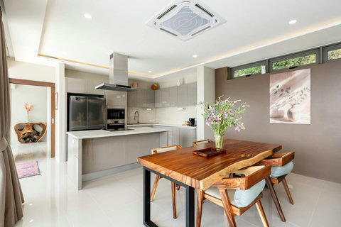Elegant dining space with natural wood table and a fully fitted kitchen.