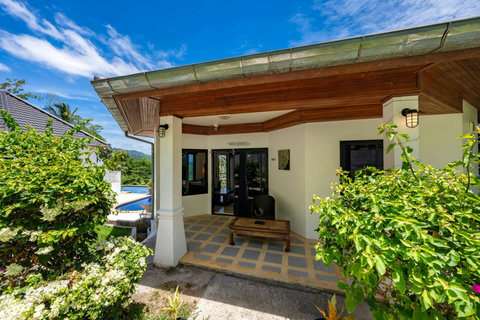 Charming hillside bungalow entrance surrounded by tropical greenery in Nathon.