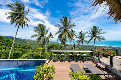 Relax by the tranquil hillside pool overlooking panoramic ocean scenery