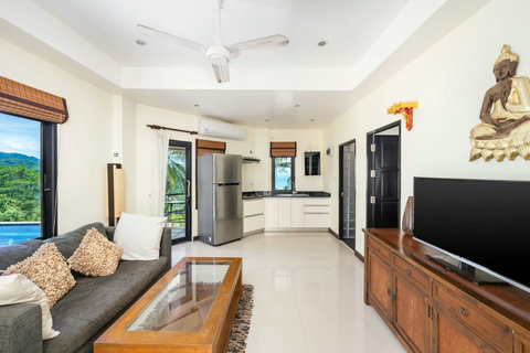 Bright open-plan living space with tropical hillside surroundings and peaceful privacy.