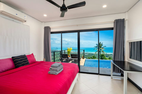 Bright master bedroom with direct pool access and uninterrupted ocean panorama."