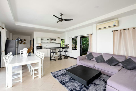 Elegant open living and dining space blending indoor comfort with tropical hillside scenery