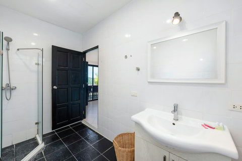 Elegant bathroom with walk-in shower and sleek dark-tile accents.