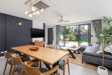 Bright open-plan living and dining area with stylish modern furnishings and pool access