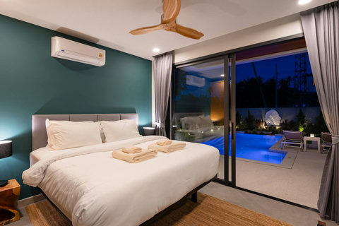 Stylish master bedroom with pool views and dark green accent wall at Villa Solaria