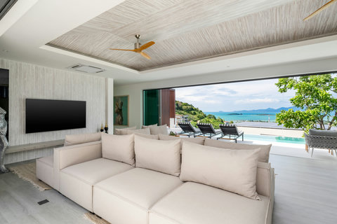 Covered outdoor lounge overlooking the pool and sea