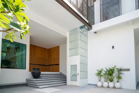Grand villa entrance with natural stone steps and tropical landscaping