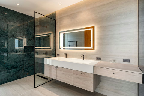 Luxurious bathroom with double vanity and backlit mirror