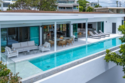 Expansive pool terrace with sun loungers and panoramic sea views