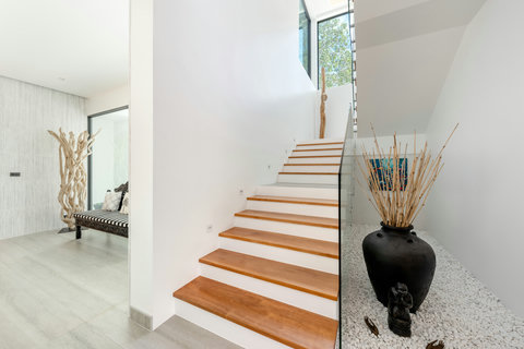 Elegant wooden staircase connecting the villa levels