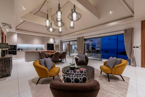Spacious living and dining room at dusk with designer furnishings ocean view terrace and ambient lighting - Villa Caprice 5-bedroom luxury retreat Santi Thani Bangpor Mae Nam Koh Samui
