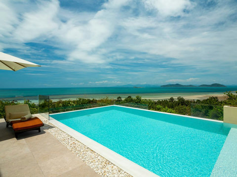 Crystal-clear turquoise pool surrounded by tropical palms and lush gardens at Villa Soluna Koh Samui