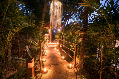 Shaded tropical garden walkway with lanterns and lush foliage leading through Villa Soluna grounds in Koh Samui