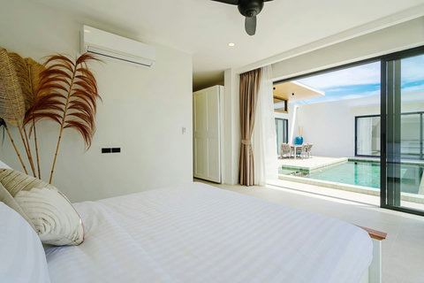 Bedroom with natural decor and sliding doors opening to the pool