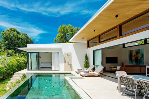 Private pool and modern villa exterior with sun loungers and open-plan living