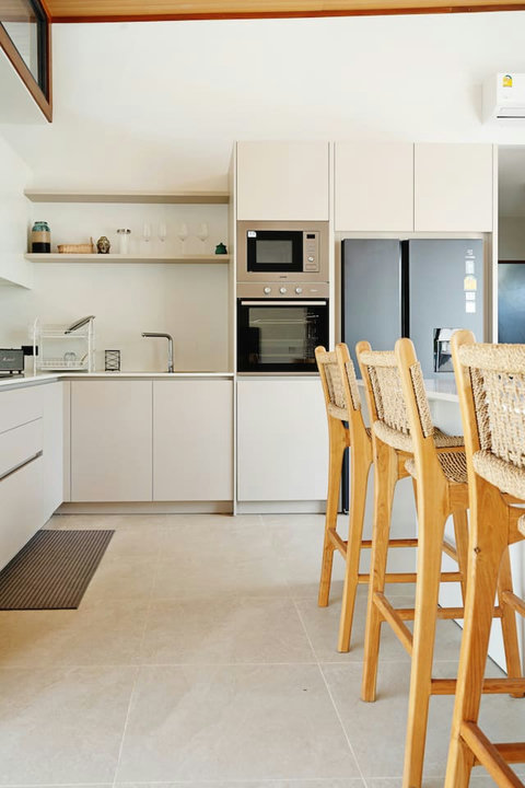 Fully-equipped kitchen with breakfast bar, rattan stools and full-size appliances