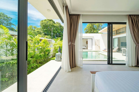 Bedroom with sliding glass doors opening to private pool and tropical garden
