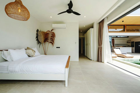 Bedroom with ceiling fan, natural decor and sliding doors to the outdoors